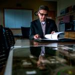 Arif Ghouse flips through his work binder in his office conference room Paine Field on Dec. 10 in Everett. (Olivia Vanni / The Herald)