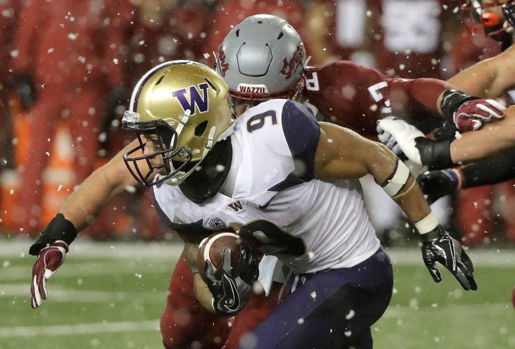 Washington running back Myles Gaskin (9) is tackled by Washington State linebacker Peyton Pelluer as he rushes during the first half of an NCAA college football game Nov. 23 in Pullman. (Ted S. Warren / AP file)