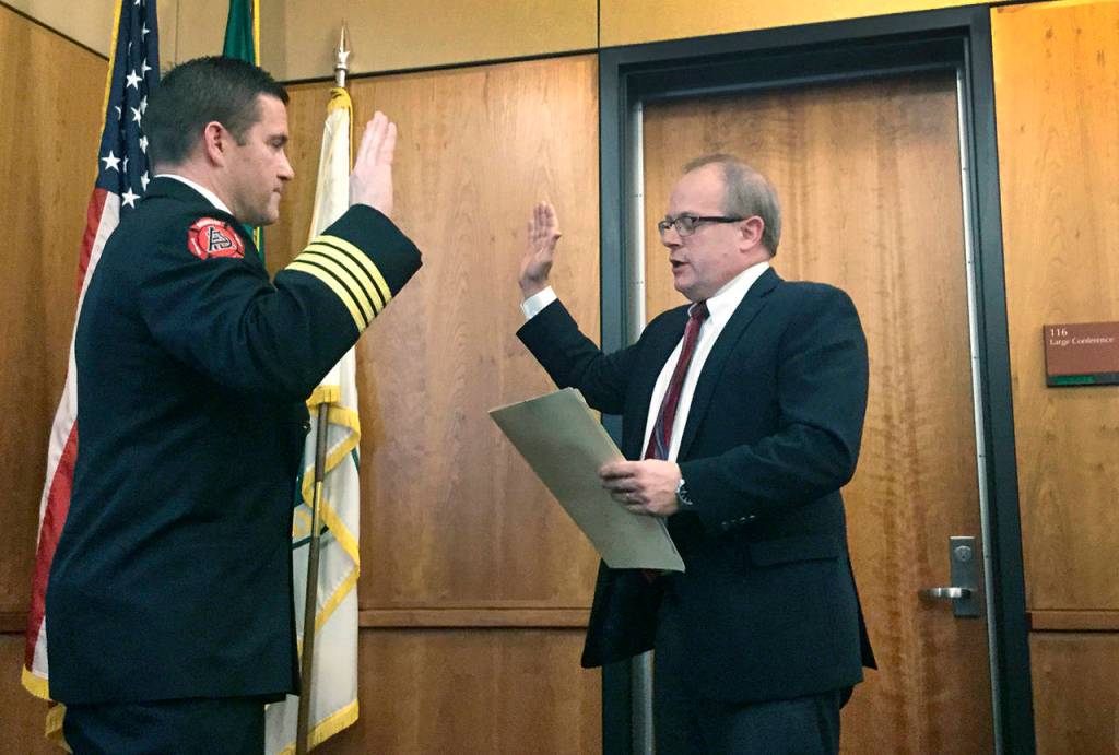 City Attorney Steve Peiffle swears in new Fire Chief Kraski. (Arlington Times)