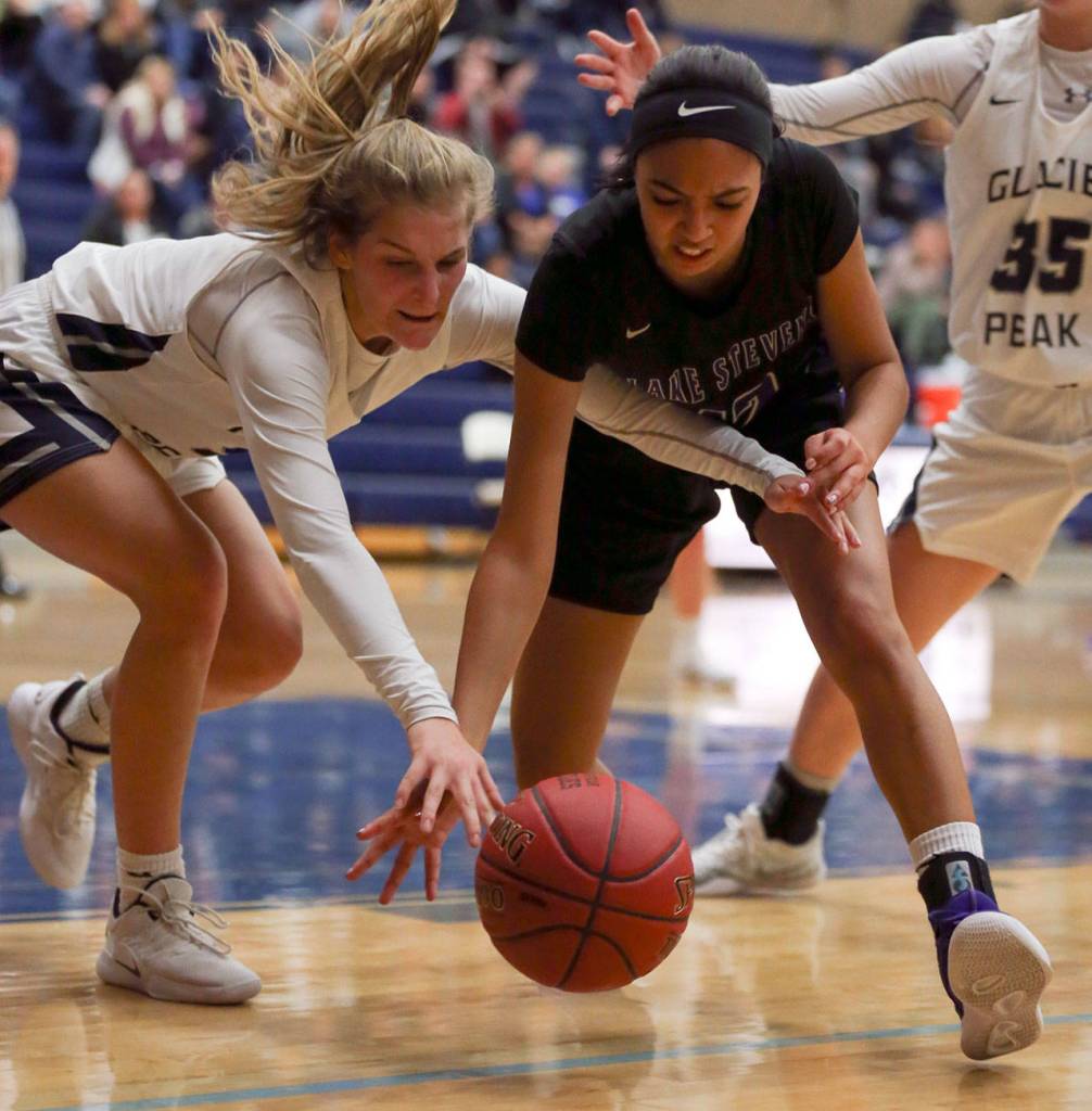 Glacier Peaks Shay Sande (left) and Lake Stevens Savannah Smith vie for a loose ball Tuesday night at Glacier Peak High School in Snohomish on December 18, 2019. Glacier Peak won 68-50. (Kevin Clark / The Herald)
