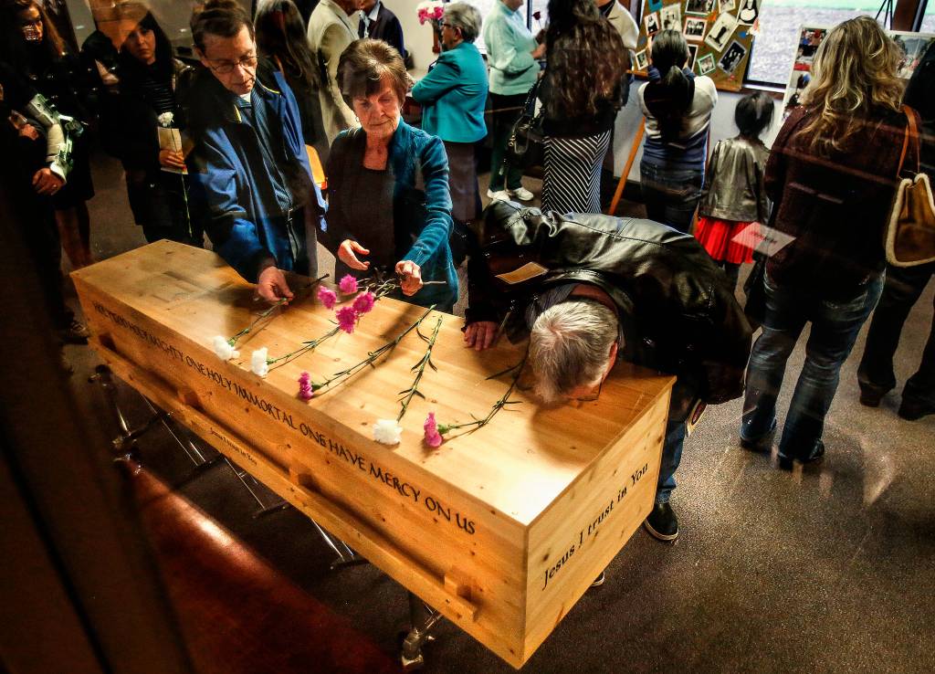 In the St. Mary of the Valley parish hall, people take a moment to touch, or even kiss the lovely wooden casket of sister Barbara Geib following Thursdays funeral Mass at the Monroe Church. (Dan Bates / The Herald)
