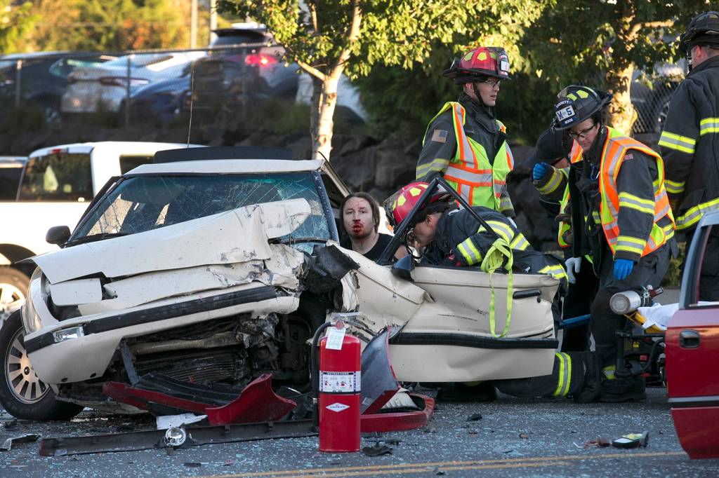 First responders work to free a driver of a two-car accident on the 7100 block of Evergreen Way Wednesday afternoon in Everett on Sept. 26. (Kevin Clark / The Herald)