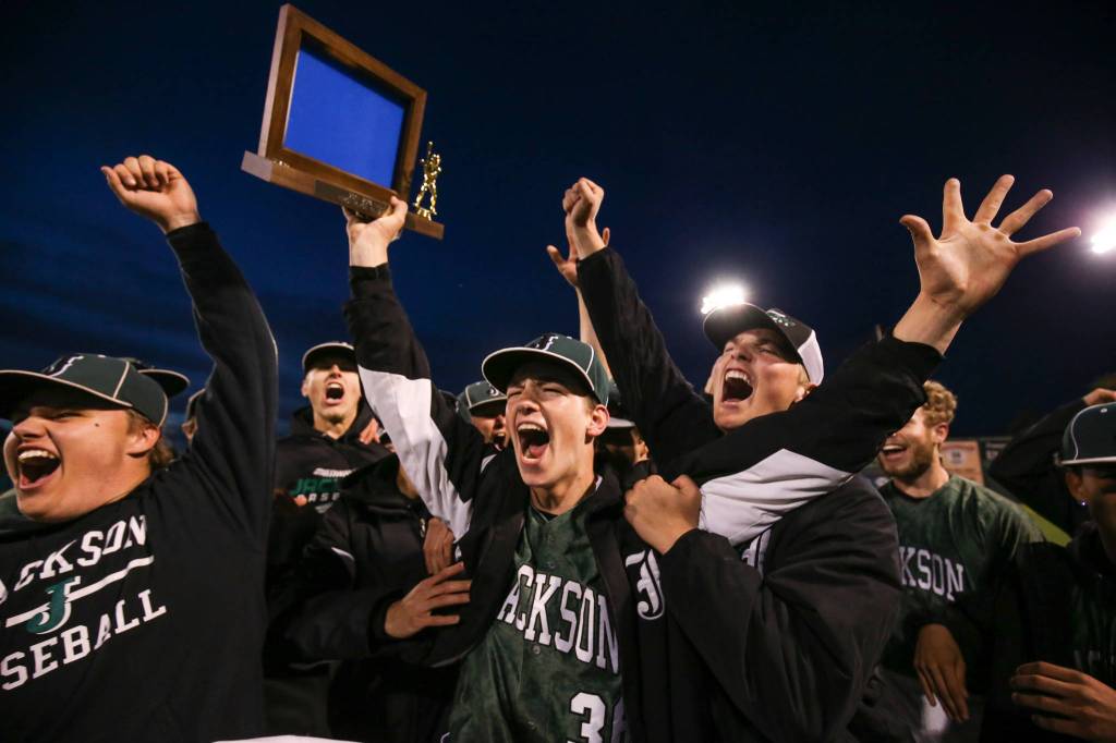 Jacksonճ Case Matters center, holds up the trophy with celebrating teammates after Jackson beat Cascade 3-0 to take the 4A district championship at Everett Memorial Stadium on Thursday, May 10, in Everett. (Andy Bronson / The Herald)