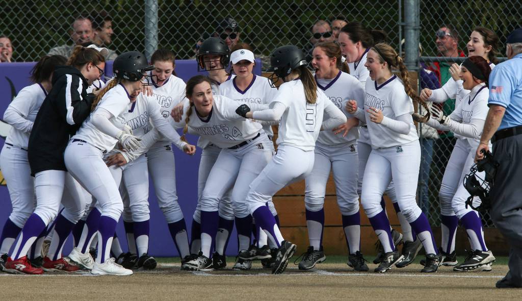 Lake Stevens Sara Johnson (14) holds back celebrating teammates so Emma Fortney (3) can touch home plate after hitting a 2-run homer to beat undefeated Jackson 3-1 on Tuesday, May 1, in Lake Stevens. (Andy Bronson / The Herald)