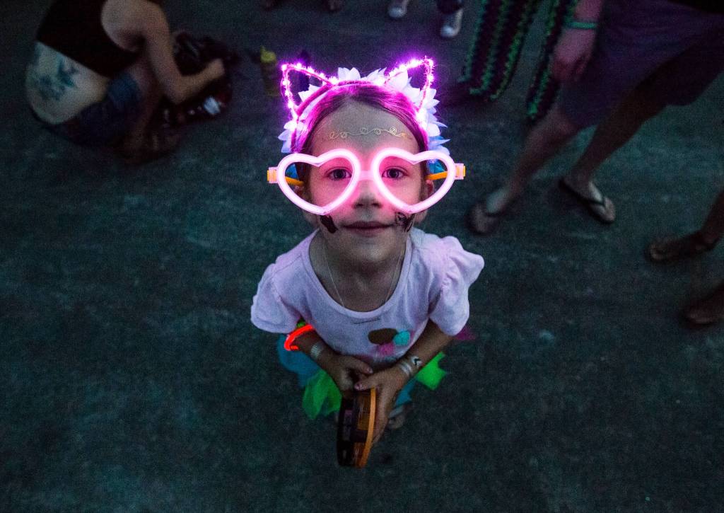 Audrey Parrish, 6, stands in the crowd at the Summer Meltdown decked out in glow stick glasses and lights on Thursday, Aug. 4, in Darrington. (Olivia Vanni / The Herald)