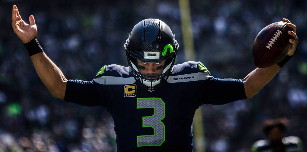 Seahawks Russel Wilson raises his arms to pump the crowd up before the game against the Dallas Cowboys on Sept. 23, in Seattle. (Olivia Vanni / The Herald)