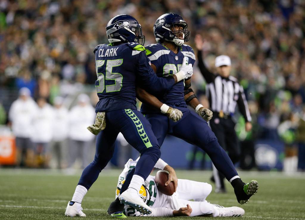 Seattle Seahawks Rashemm Green, right, celebrates after sacking and stepping over Green Bay Packers Aaron Rodgers as the Hawks beat the Green Bay Packers 27-24 at Century Link Field on Thursday, Nov. 15, in Seattle. (Andy Bronson / The Herald)