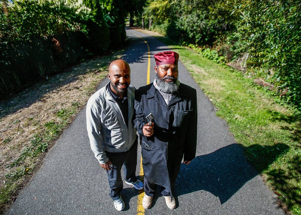 Woldesemait Teklehaymanot (right), a leader of Debre Selam Kidus Michael Ethiopian Orthodox Tewahido Church in Edmonds, and Henoke Hadera pause during their daily walk along the Interurban Trail in Lynnwood. (Dan Bates / The Herald)