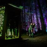 Two friends hug each other as they explore the Axis Mundi art installation at the Summer Meltdown on Thursday, Aug. 2, in Darrington. (Olivia Vanni / The Herald)