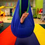 Friday at Wee Fit, Hunter Standley, 6, enjoys a longer than usual moment relaxing, and that is the idea. It is called a pod swing and is soft and comfortable, as well as acting as a shield against bright light. Hunter, who has autism, is with his mom, Breanna Standley, 25, and his grandmother, Barbara Bambrick, 63. They are from Tulalip. (Dan Bates / The Herald)