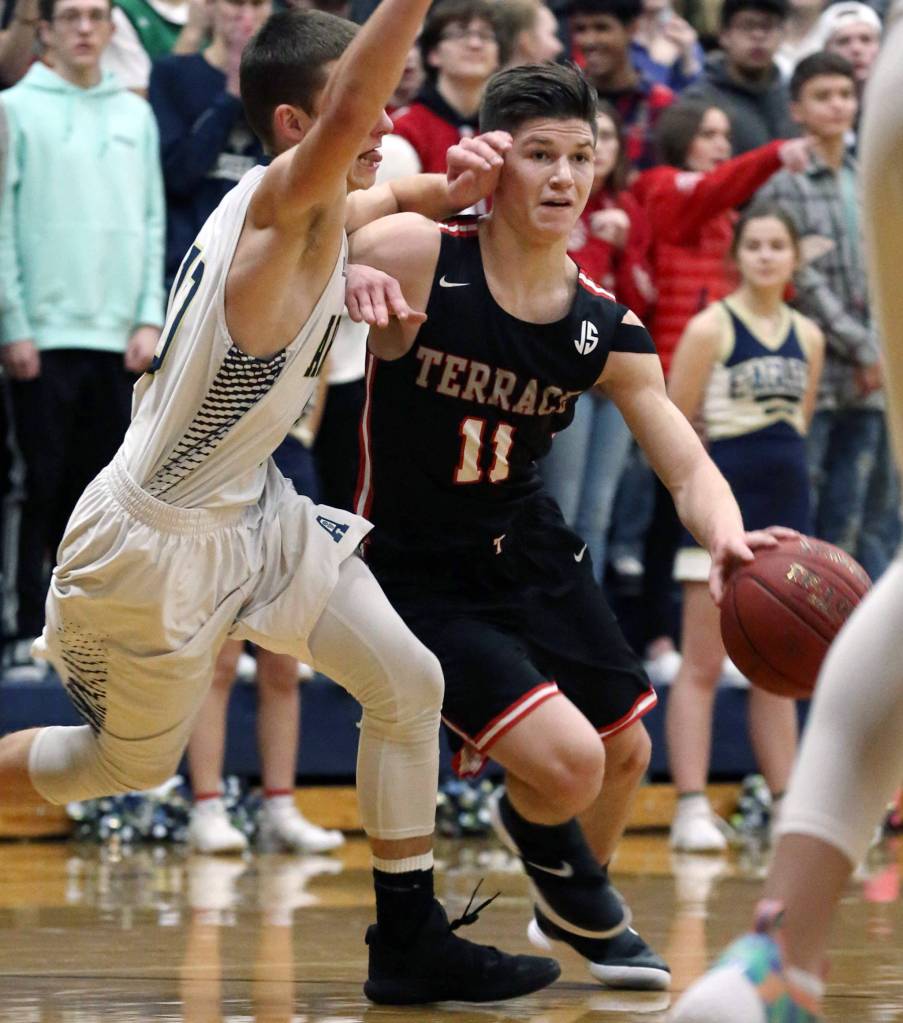 Mountlake Terraces Mason Christianson drives the lane with Arlingtons Anthony Whitis defending at Arlington High School on Dec. 21. Mountlake Terrace won 69-67. (Kevin Clark / The Herald)