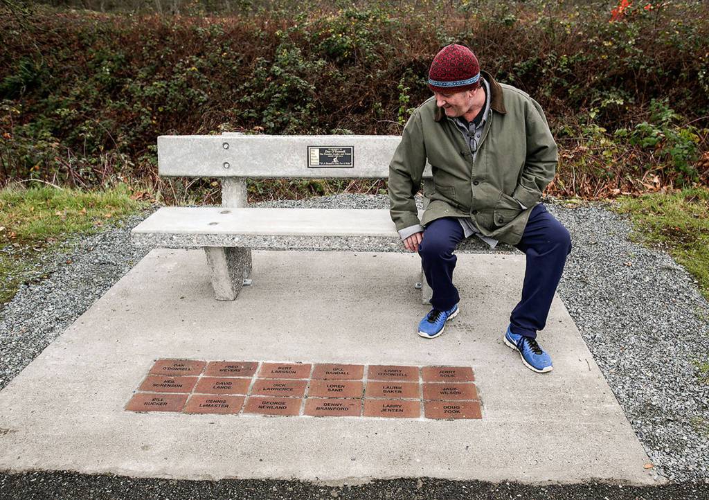 Steve ODonnell looks over a concrete bench in honor of his father, Dan, along the Centennial Trail on Dec. 19 in Arlington. Dan was the founder of <a href="https://www.heraldnet.com/news/enjoying-the-cycles-of-life/" target="_blank">The Big Shots</a> bicycle group, whose members names are inscribed in bricks at the base of the bench. (Andy Bronson / The Herald)
