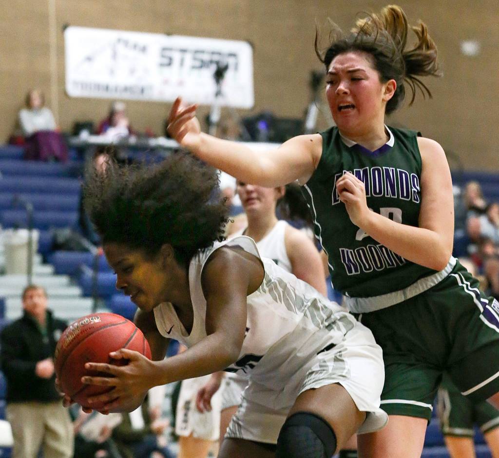 Chinas Mykila Burton gets a rebound in front of Edmonds-Woodways Maddie McMahon during the Top of the Peak Tournament at Glacier Peak High School in Snohomish on Dec. 27. Chiawana won 60-43. (Kevin Clark / The Herald)