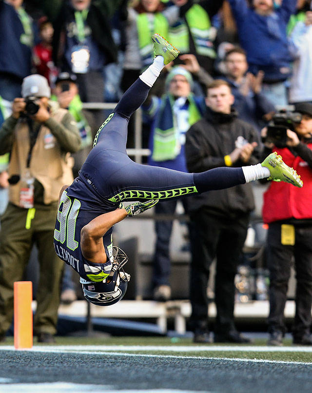 Seattles Tyler Lockett flips as he crosses the end zone for a first-quarter touchdown during the Seahawks 27-24 win over Arizona on Sunday at CenturyLink Field in Seattle. The touchdown made Russell Wilson the franchise leader in career passing touchdowns. (Andy Bronson / The Herald)