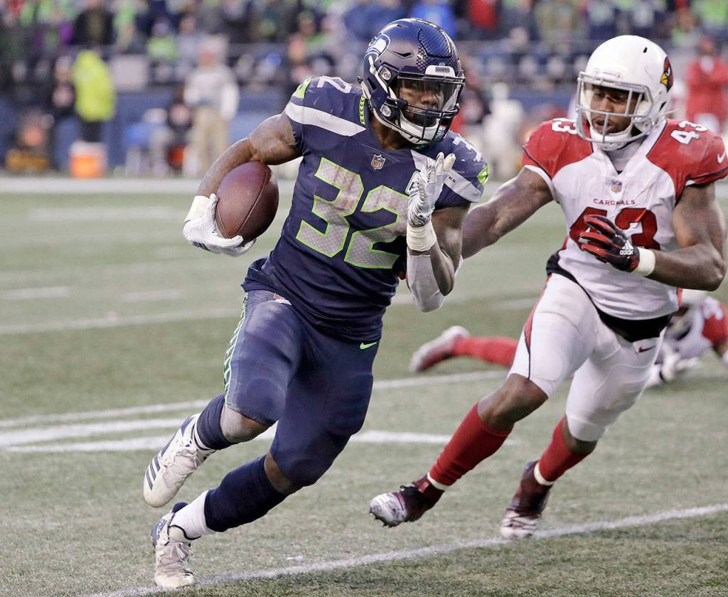 Seattles Chris Carson (32) runs upfield as Arizonas Haason Reddick (43) pursues during the Seahawks 27-24 win over Arizona on Sunday at CenturyLink Field in Seattle. (AP Photo/Ted S. Warren)