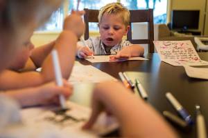 Landon Weewie, 5, concentrates while he works on a thank you card for the firefighters. (Olivia Vanni / The Herald)