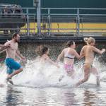 Late arrivals hit the water after the first wave of participants leave Tuesday, Jan. 1, during the annual Polar Bear Plunge at Bracketts Landing in Edmonds. (Andy Bronson / The Herald)
