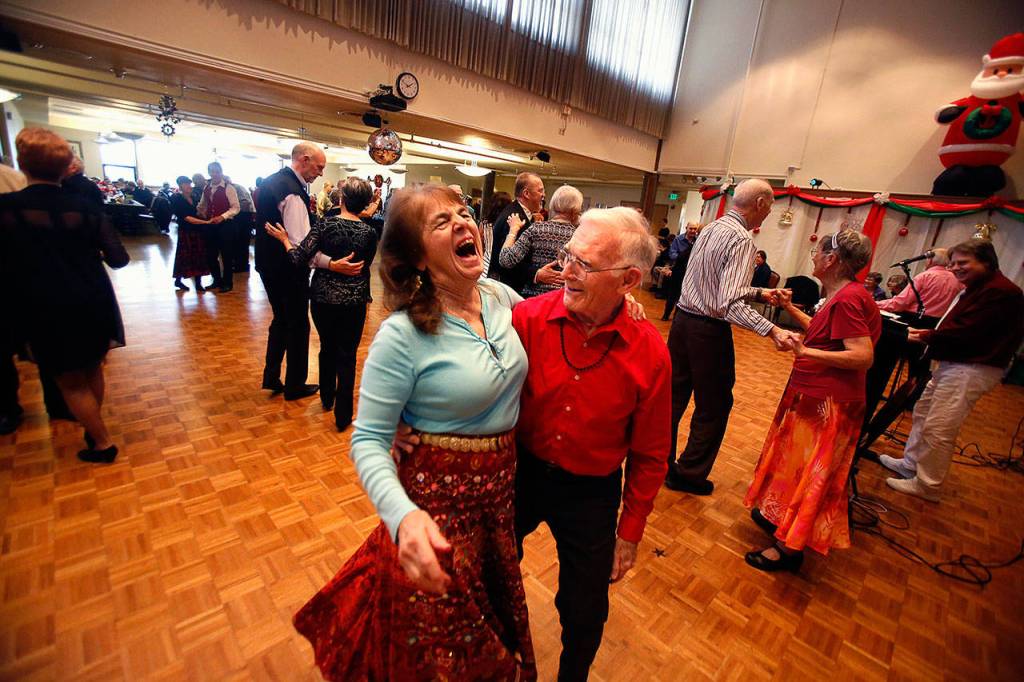 Linda Perry, 76, enjoys a big laugh between songs with dance partner John Wagner, 88. (Dan Bates / The Herald)