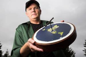 Mark Sargent holds a representative model of a flat planet. The Whidbey Island native has made a name for himself as a flat Earth spokesman. (Andy Bronson / The Herald)