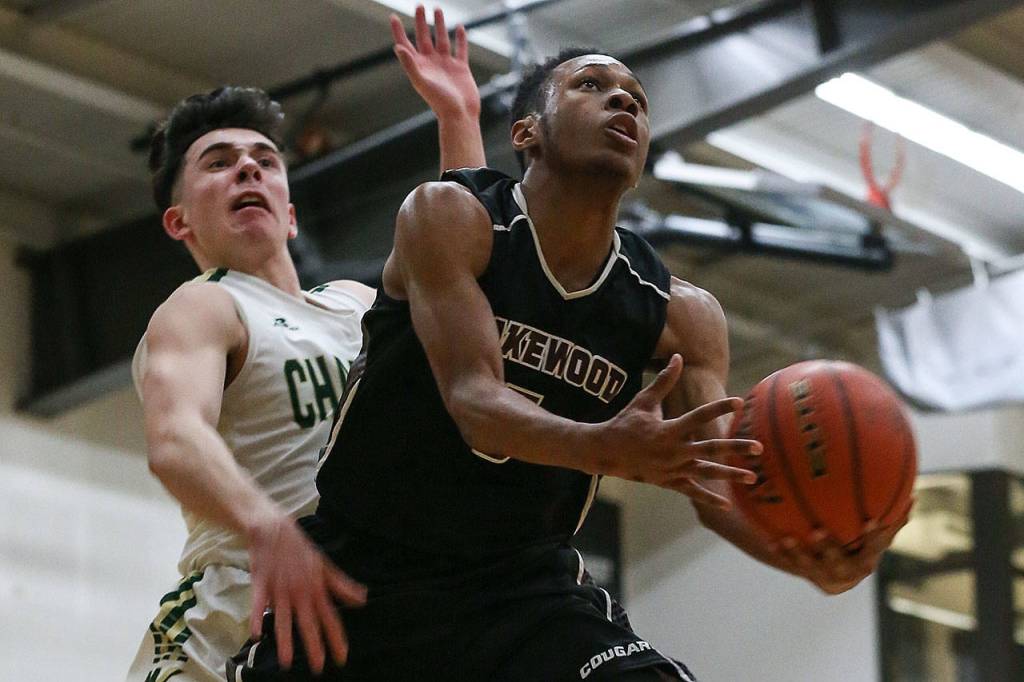 Lakewoods Michai Harris goes up for a layup as Marysville Getchells Chase Showalter defends during a non-conference game Wednesday in Marysville. Harris and the Cougars beat Showalter and the Chargers 62-54. (Kevin Clark / The Herald)