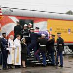 The flag-draped casket of former President George H.W. Bush is carried by a joint services military honor guard Thursday, Dec. 6, 2018, in Spring, Texas, as it is placed on a Union Pacific train. Bryce Carnahan is on the far left. (AP Photo/David J. Phillip, Pool)