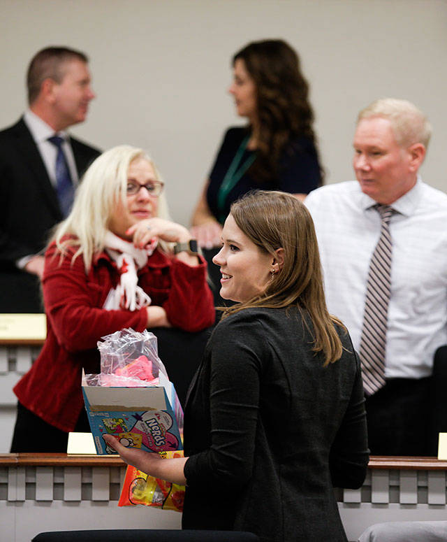 Rep.-elect Lauren Davis, D-Shoreline (center), hands out candy to colleagues before the start of an orientation session for new House members Wednesday at the Capitol. (Andy Bronson / The Herald)