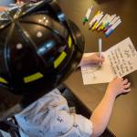 One of the <a href="https://www.heraldnet.com/news/fire-ruined-their-home-but-everett-family-of-9-stays-strong/" target="_blank">Weewie</a>s children draws a firefighter on a thank-you card on Nov. 14 in Everett. (Olivia Vanni / The Herald)