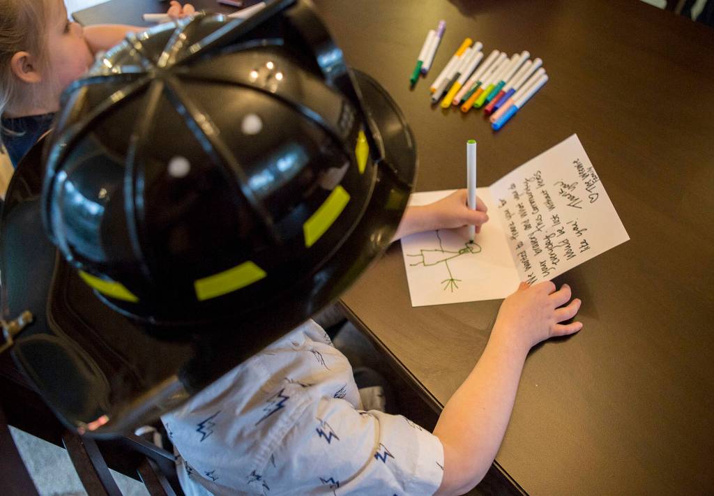 One of the <a href="https://www.heraldnet.com/news/fire-ruined-their-home-but-everett-family-of-9-stays-strong/" target="_blank">Weewie</a>s children draws a firefighter on a thank-you card on Nov. 14 in Everett. (Olivia Vanni / The Herald)
