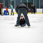 Gavin Bell, 8, looks up at his dad during the community skate after slipping at the XFINITY Community Ice Rink on Dec. 28 in Everett. (Olivia Vanni / The Herald)