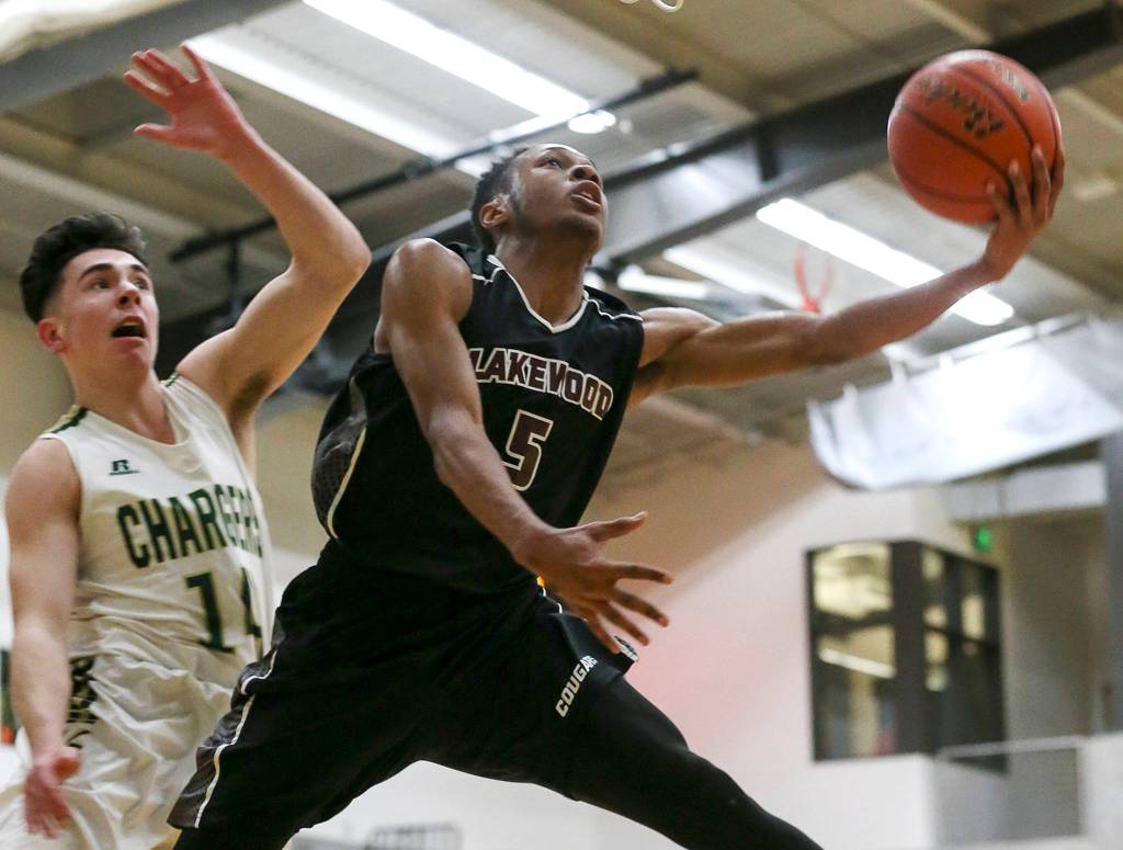 Lakewoods Michal Harris attempts a shot with Marysville-Getchells Chase Showalter trailing at Marysville-Getchell High School on Jan. 2. The Cougars won 62-54. (Kevin Clark / The Herald)