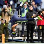 Tyler Lockett flips as he crosses the end zone for a touchdown as the Seattle Seahawks led the Arizona Cardinals 7-3 in the first quarter at CenturyLink Field on Dec. 30 in Seattle. The touchdown made Russell Wilson the leader in passing touchdowns in Seahawks history. (Andy Bronson / The Herald)