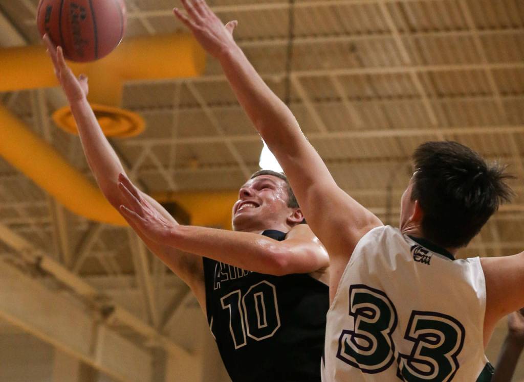 Arlingtons Anthony Whitis (left) attempts a shot with Edmonds-Woodways Tai Starchman defending during a Wesco 3A boys basketball game Wednesday at Edmonds-Woodway High School. Whitis scored 15 points for the Eagles in a 74-71 loss. (Kevin Clark / The Herald)