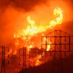 In this 2017 photo, flames burn near power lines in Sycamore Canyon near West Mountain Drive in Montecito, California. (Mike Eliason/Santa Barbara County Fire Department via AP, File)