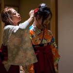 Shoka Ludden, left, helps Reika Nemoto, right, re-pin part of her headpiece before the Coming of Age ceremony at Everett Community College. (Olivia Vanni / The Herald)