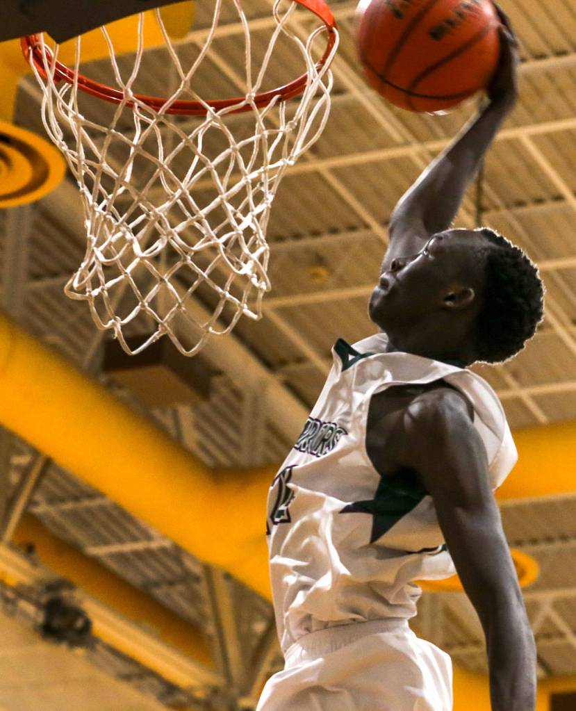 Edmonds-Woodways Muting Bol dunks in the third quarter against Arlington at Edmonds-Woodway High School in Edmonds on Jan. 9. The Warriors won 74-71. (Kevin Clark / The Herald)