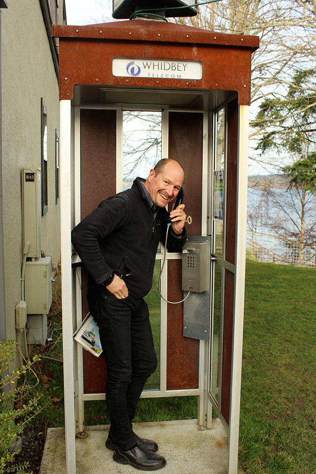 George Henny stands at one of 35 pay telephone booths Whidbey Telecom preserved and turned into a place to make free local calls. (Patricia Guthrie/Whidbey News Group)