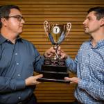 Edmonds Community College athletic director Spencer Stark (left) and Everett Community College athletic director Garet Studer hold the T Trophy at Everett Community College on Thursday. (Olivia Vanni / The Herald)