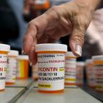 Family and friends who have lost loved ones to OxyContin and opioid overdoses leave pill bottles in a 2018 protest outside the headquarters of Purdue Pharma, which is owned by the Sackler family, in Stamford, Connecticut. A new filing in a Massachusetts case ramps up the legal and financial pressure against the Sackler family, which owns the company that makes OxyContin. (AP Photo/Jessica Hill, File)