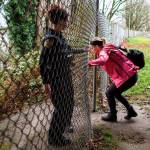 Everett Police officer Inci Yarkut (left) holds an opening in a fence for social worker Kelli Roark as they check encampments during the annual Point-in-Time count of homeless people on Wednesday in Everett. (Olivia Vanni / The Herald)