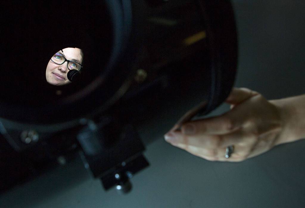 Physicist Joey Shapiro Key is shown reflected through a Celestron reflecting telescope in her lab at the UW Bothell campus on Jan. 11, 2019 in Everett. (Olivia Vanni / The Herald)