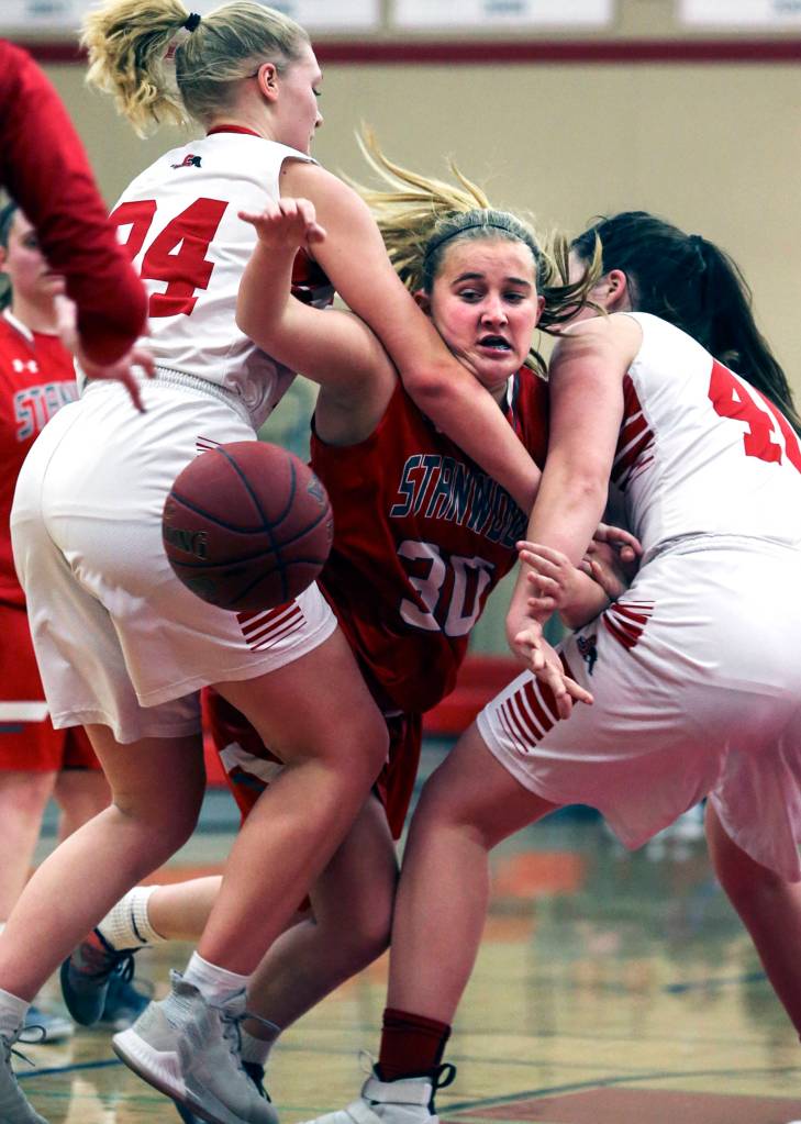 Stanwoods Madeline Larson (center) attempts to split the defenses of Snohomishs Kaylin Beckman (left) and Courtney Perry at Snohomish High School on Jan. 17, 2019. The Panthers won 55-38. (Kevin Clark / The Herald)