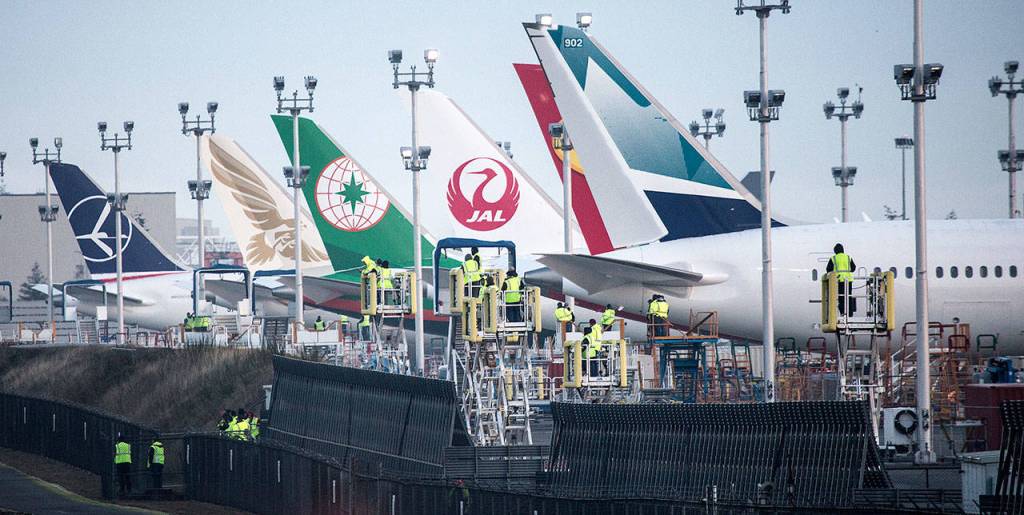 Boeing employees watch as two Boeing KC-46 Pegasus tankers take off from Paine Field on Friday in Everett. (Andy Bronson / The Herald)