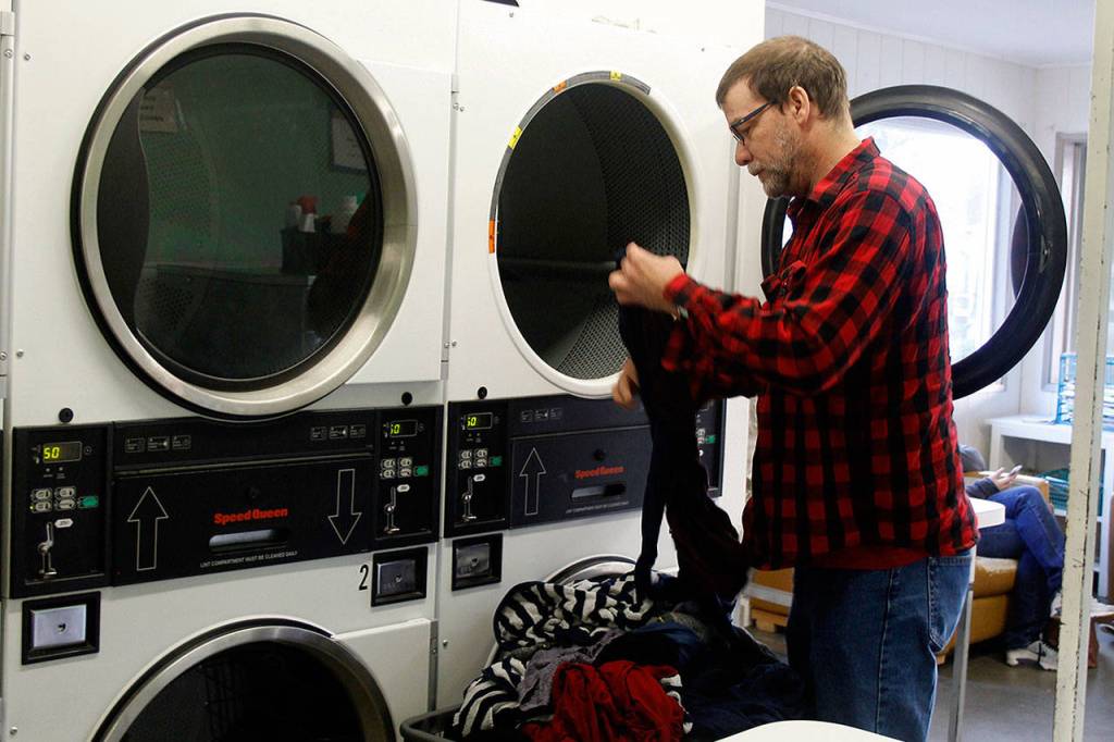 Ben Wooldridge makes more trips to do laundry than before the fire because he uses more towels for his burn recovery treatment. (Patricia Guthrie / Whidbey New Group)