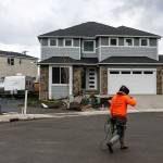 A construction worker walks by houses under construction in a cul-de-sac on 8th Place SE on Wednesday, March 8, 2017, in Lake Stevens, Wa. (Ian Terry / The Herald)