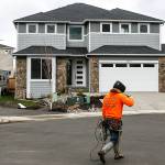 A construction worker walks by houses under construction in Lake Stevens in 2017. (Herald file)