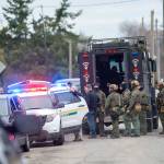 The State Patrol SWAT team gathers after serving a warrant Thursday morning that led to the arrest of a man suspected to be involved in the triple homicide discovered New Years Eve. (Jesse Major / Peninsula Daily News)
