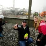 Michael and Heather Wallace take selfies after signing their names on the final beam for the roof of the new YMCA building on Colby Avenue in Everett on Friday. (Andy Bronson / The Herald)