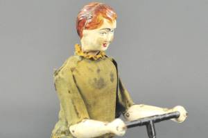 Tin boy-on-a-scooter toy is key-wound and rolls across floor