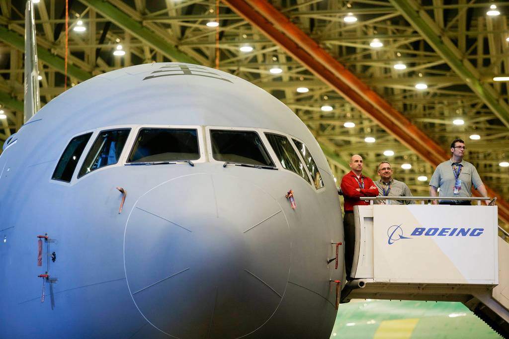 Boeing employees watch the <a href="https://www.heraldnet.com/business/for-a-day-troubles-are-forgotten-as-boeing-delivers-tankers/" target="_blank">KC-46 Pegasus delivery event</a> from the air stairs at Boeing on Jan. 24 in Everett. (Andy Bronson / The Herald)