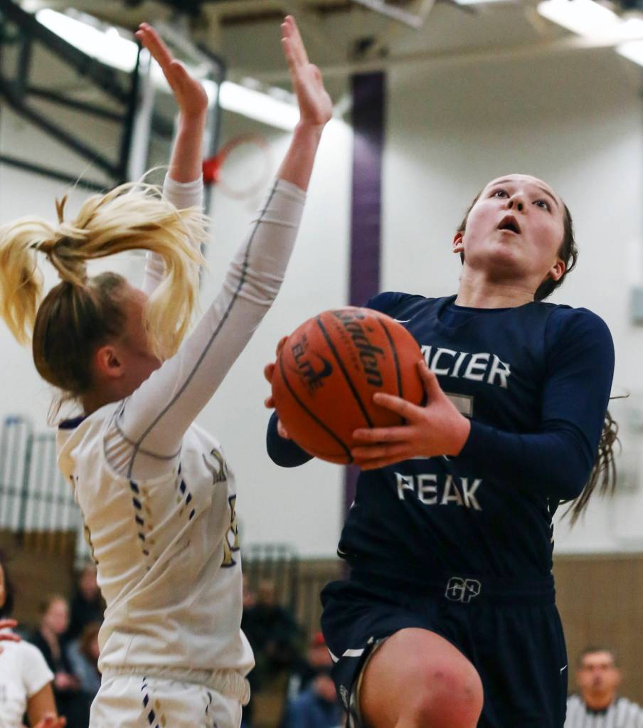 Glacier Peaks Maya Erling (right) attempts a shot with Lake Stevens Chloe Pattison defending at Lake Stevens High School on Jan. 22. Glacier Peak won 67-48. (Kevin Clark / The Herald)